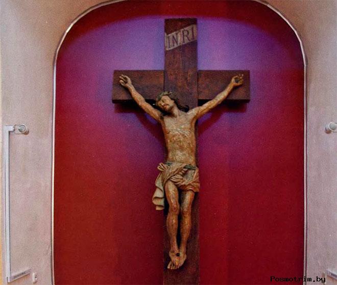 Типичное для католической традиции Распятие: тело Спасителя провисает на руках, ступни скрещены и пробиты одним гвоздем