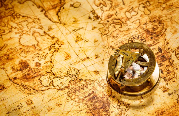 Старинный компас находится на древней мировой карте Стоковое Фото