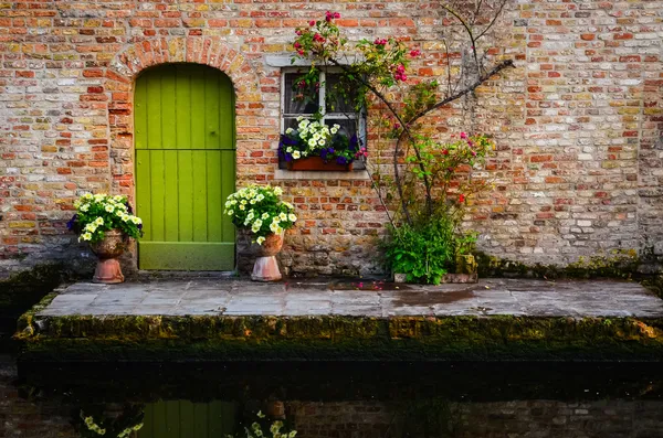 Винтаж старая стена с зеленой дверью и цветы Лицензионные Стоковые Фото