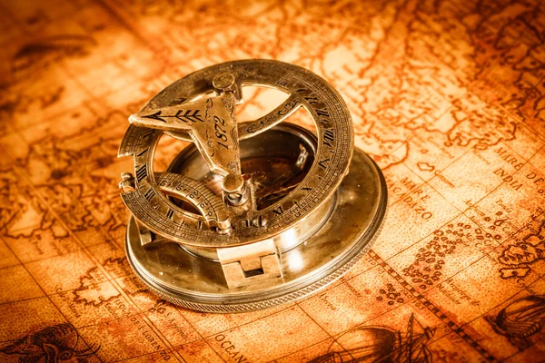 Старинный компас находится на древней мировой карте Стоковая Картинка