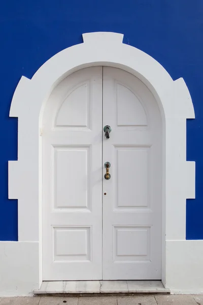 Красивые белые двери на голубой стене Стоковая Картинка
