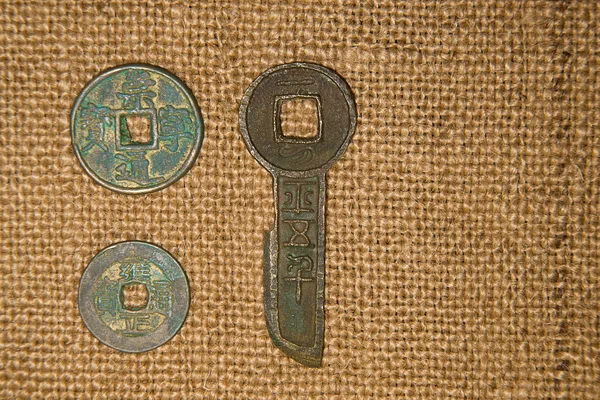 Древние китайские бронзовые монеты на старой ткани Стоковое Изображение