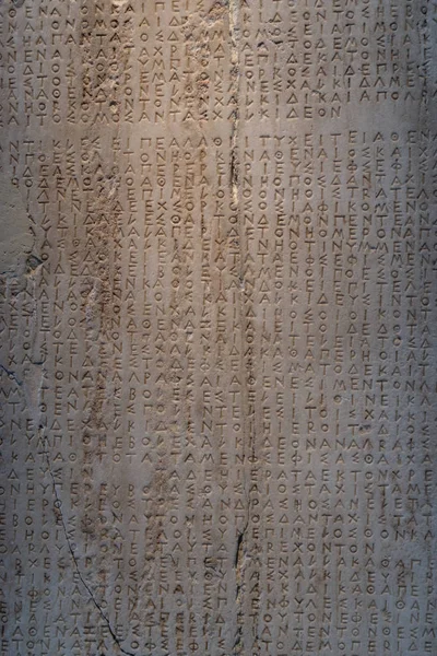 Древние греческие слова, высеченных в камне с трещинами Стоковая Картинка